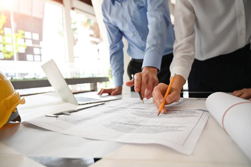 Réunion de l'architecte de l'équipe et consultation avec le plan directeur et l'ordinateur dans le bureau d'architecture.